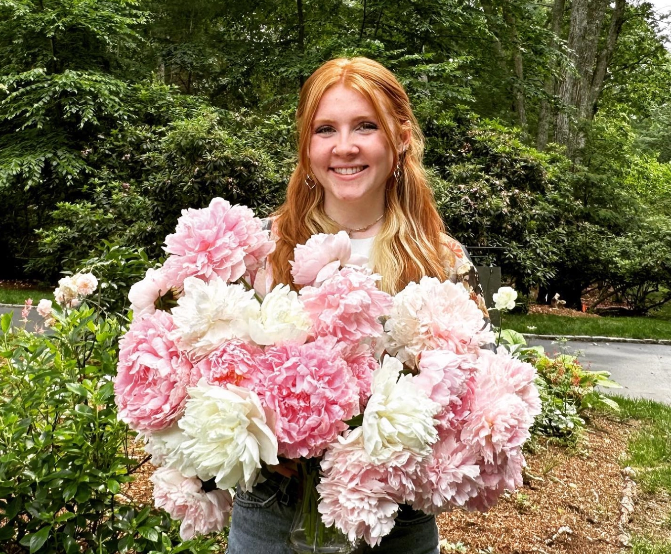 Catherine McGonagle, STEMS Co-Founder & President, holding a bunch of pink dahlias