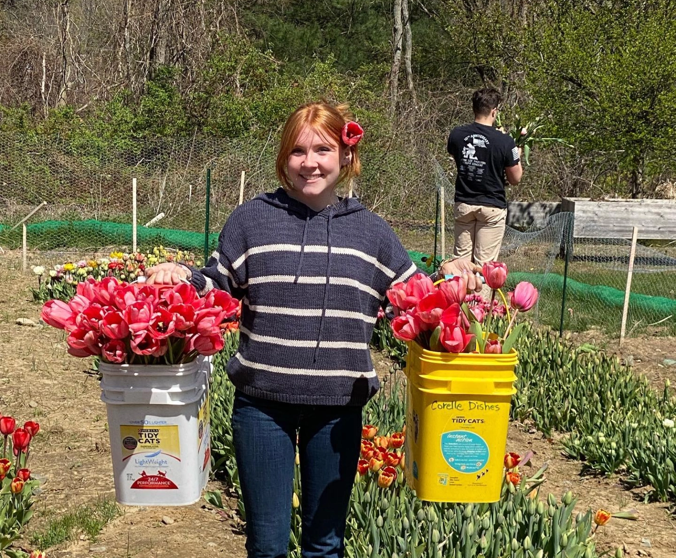 Catherine McGonagle, STEMS Co-Founder & President, holding two buckets of pink tulips