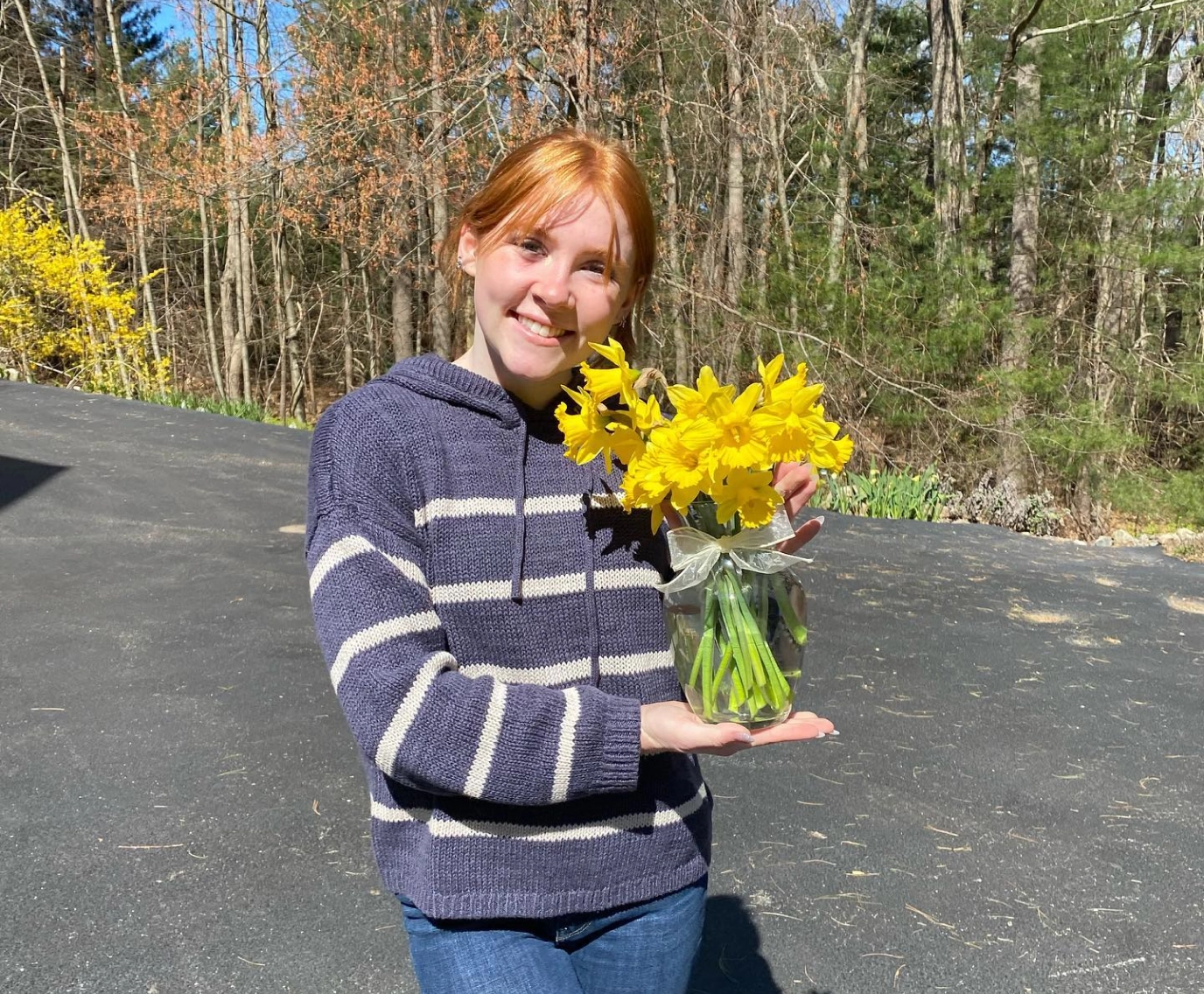 Catherine McGonagle, STEMS Co-Founder & President, holding a vase of yellow flowers