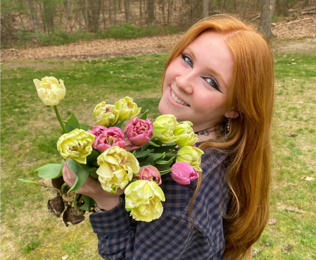 Catherine McGonagle, STEMS Co-Founder & President, holding a dozen flowers